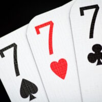 Card game hand with three cards all sevens